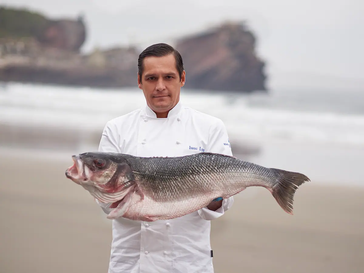 Isaac Loya con un pescado del Cantábrico en la playa de Salinas